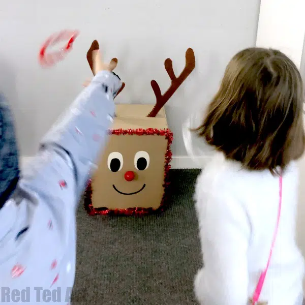 Children throwing rings on the antlers of a DIY reindeer made from a cardboard box