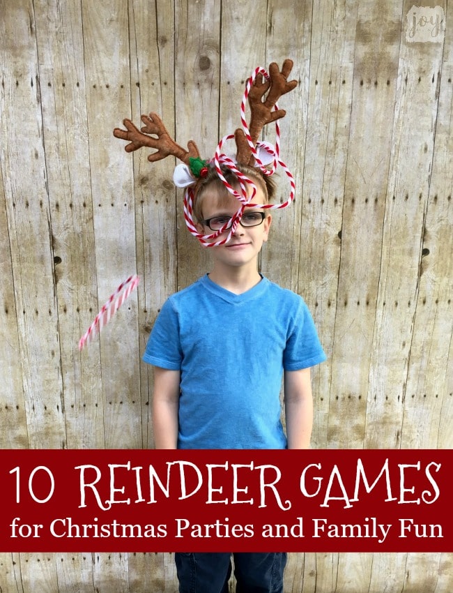 Boy with reindeer antlers with red and white rings being thrown on the antlers as a fun Christmas party game